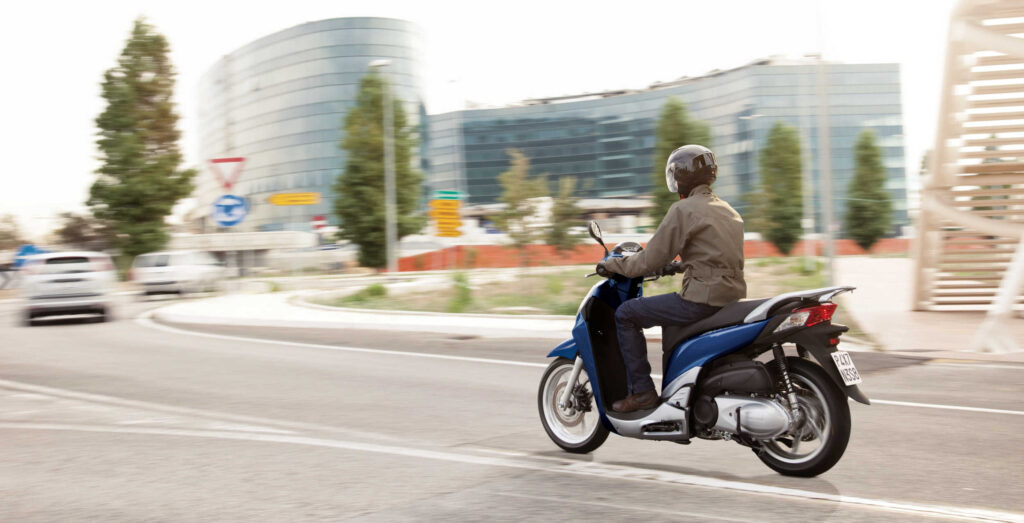2-wheel scooter being ridden in the city