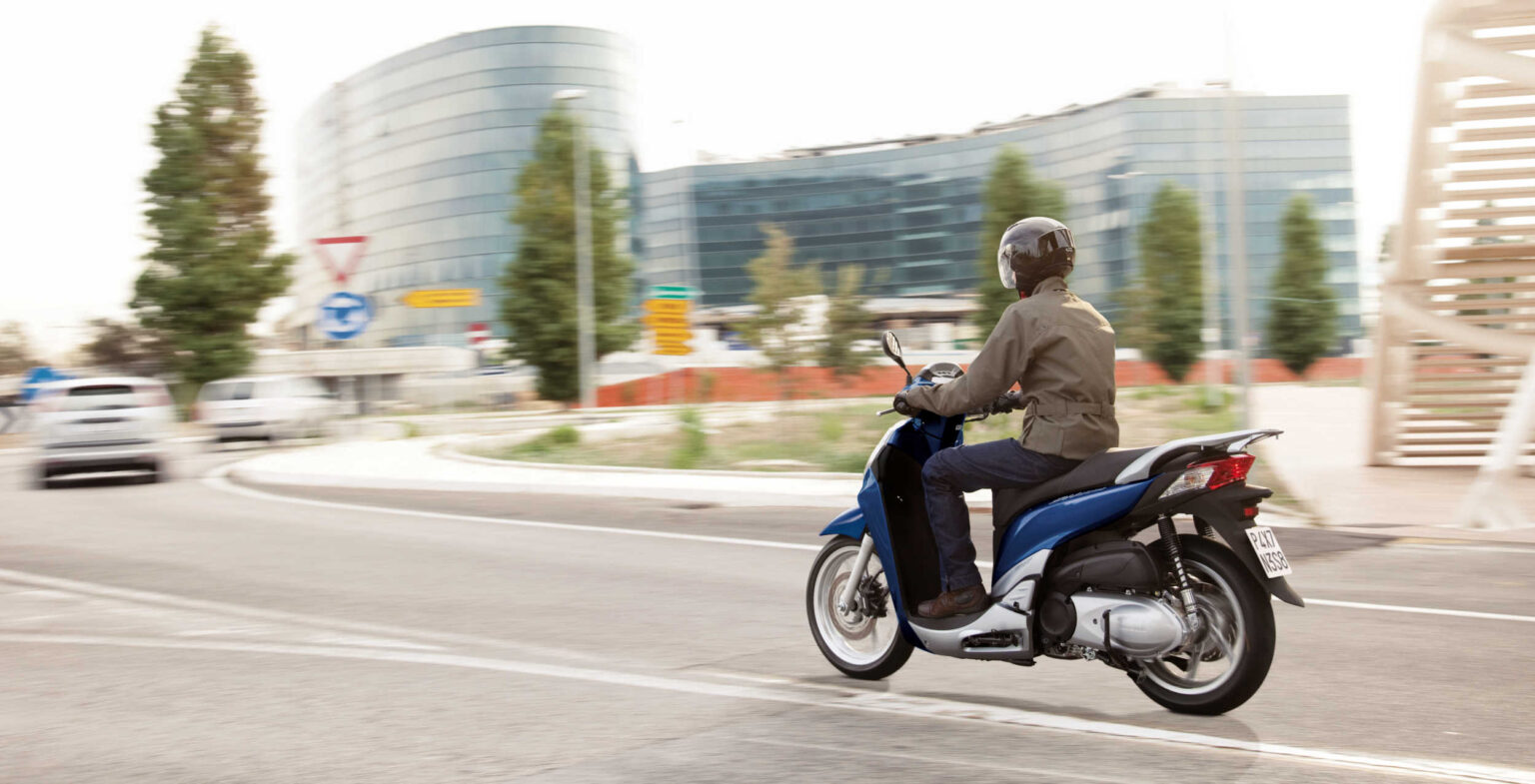 2-wheel scooter being ridden in the city